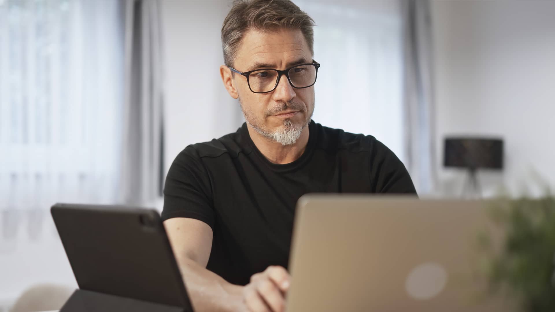 Konzentrierter Mann liest im Homeoffice die Steuernews für Kroatien im Juni 2025 auf seinem Laptop.