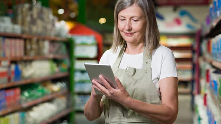 Retired woman working in a store using a digital tablet - Croatian Retirees Are Working More Than Ever