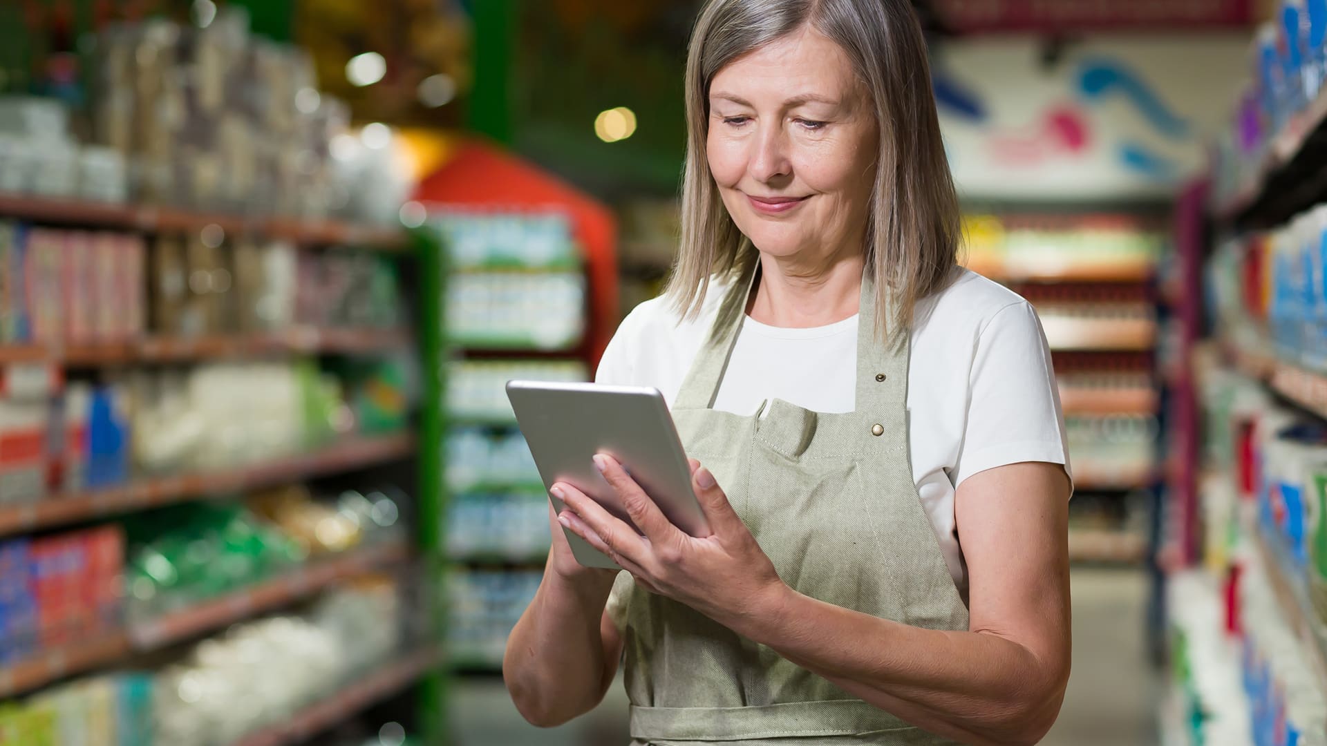 Retired woman working in a store using a digital tablet - Croatian Retirees Are Working More Than Ever