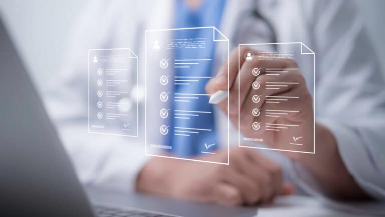 Doctor reviewing digital medical records and documents on a transparent screen.