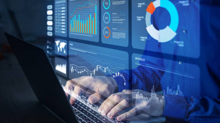 Hands typing on a laptop keyboard with digital charts and analytics displayed, symbolizing eInvoicing and fiscal digitalization.