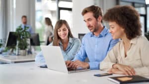 Business professionals collaborating at a laptop in a modern office, representing tax advisory and financial updates in Croatia.