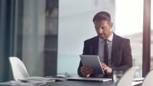 Business professional reviewing information on a tablet in a modern office, representing tax updates and financial developments in Croatia.