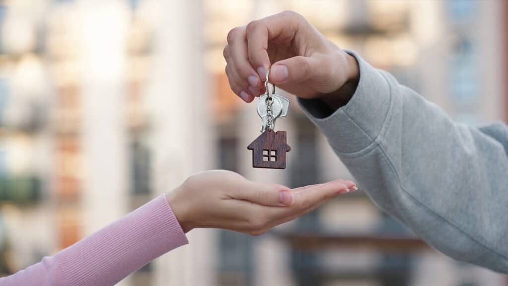 A person hands over apartment keys to a tenant, symbolizing property rental and tax obligations for foreign property owners in Croatia.