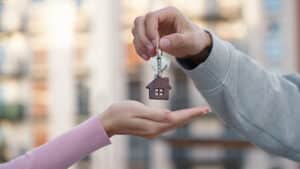 A person hands over apartment keys to a tenant, symbolizing property rental and tax obligations for foreign property owners in Croatia.