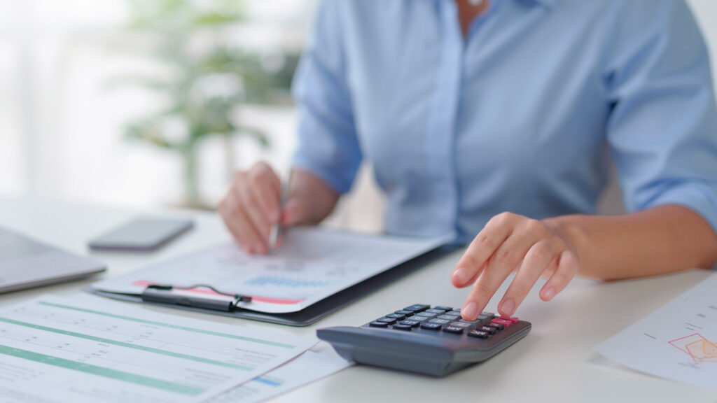 Calculator, pen and financial reports on a desk, illustrating Croatia's proposed tax on excess profit margins